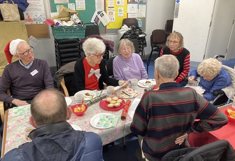 community-members-sit-around-table-completing-a-quiz