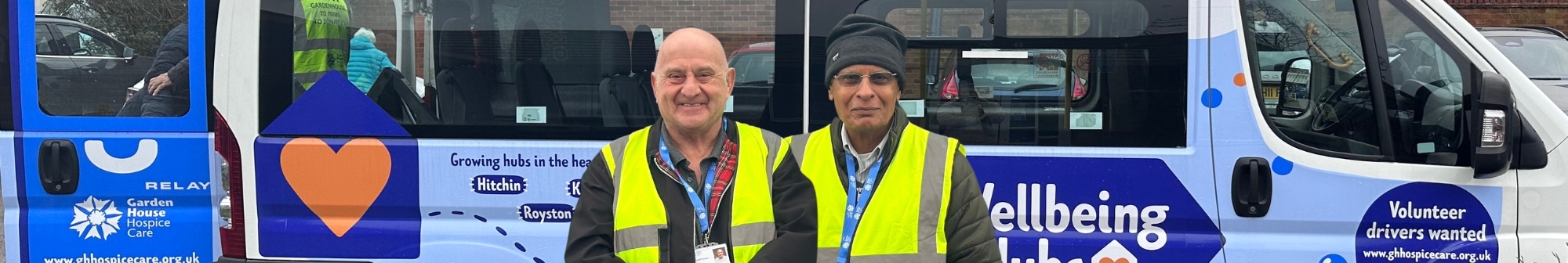 two-volunteer-drivers-and-chaperones-smiling-outside-the-minibus