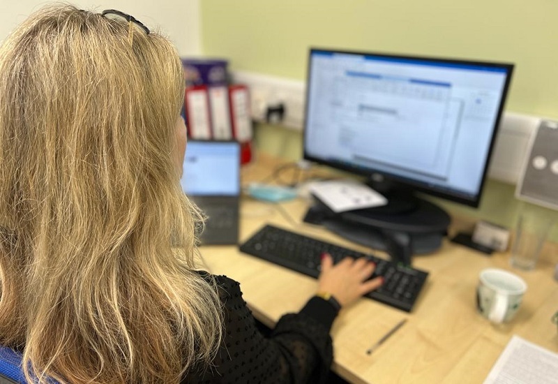 photo-taken-over-womans-shoulder-of-her-using-office-computer