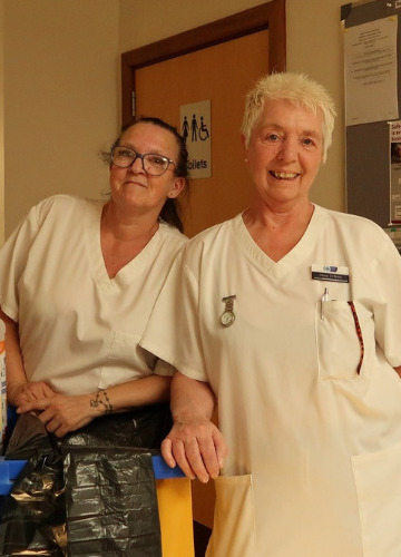 two-members-of-house-keeping-team-pose-with-cleaning-trolley (cropped)