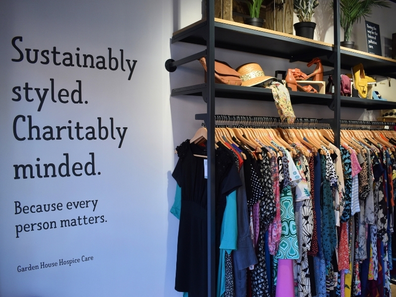 a-wall-vinyl-reading-sustainably-styled-charity-minded-beside-rails-of-clothes