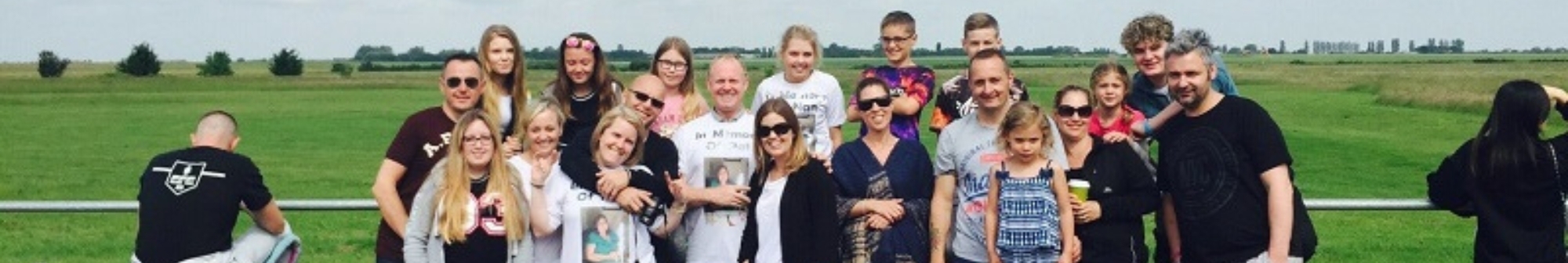 a-large-family-stand-around-picnic-table-in-front-of-field