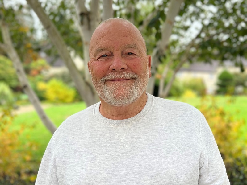 john-stands-in-the-hospice-gardens-smiling-at-the-camera