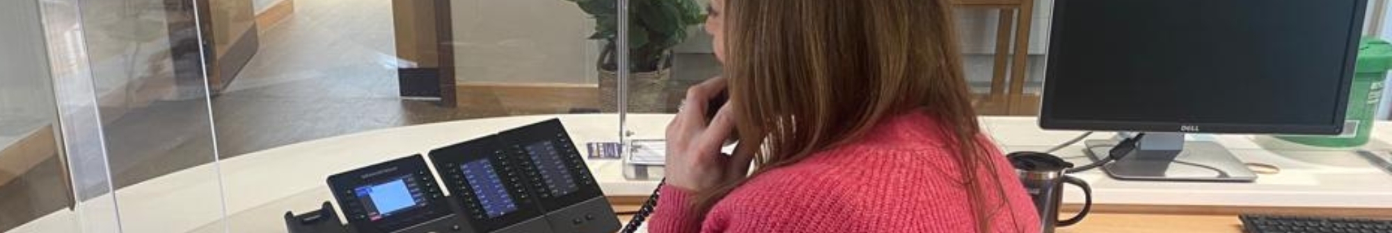 over-the-shoulder-shot-of-volunteer-receptionist-on-phone