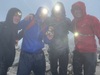 four-challengers-wearing-headtorches-at-the-top-of-a-mountain