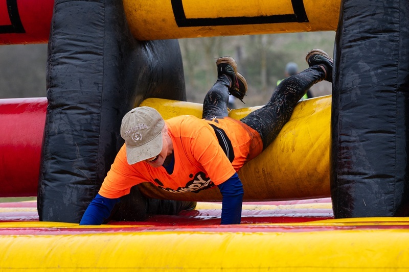 participant-dives-head-first-through-inflatable-muddy-obstacle