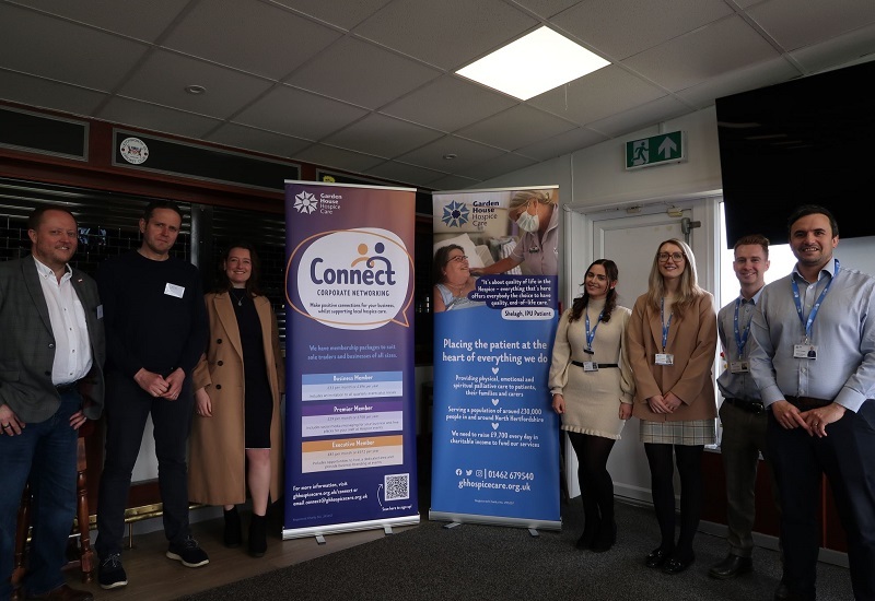 hospice-staff-and-connect-members-stand-next-to-pull-up-banners