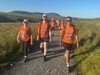 three-people-smile-walking-toward-camera-on-the-yorkshire-three-peaks-challenge