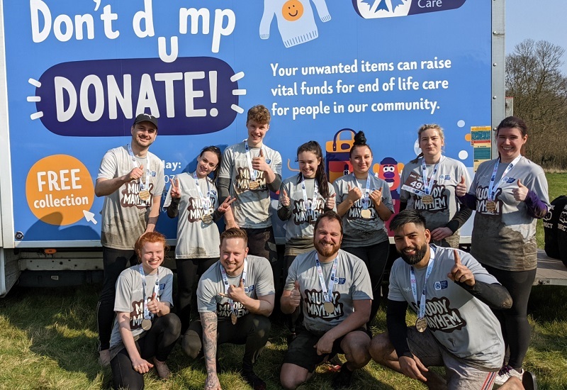 corporate-team-after-muddy-mayhem-in-front-of-hospice-van