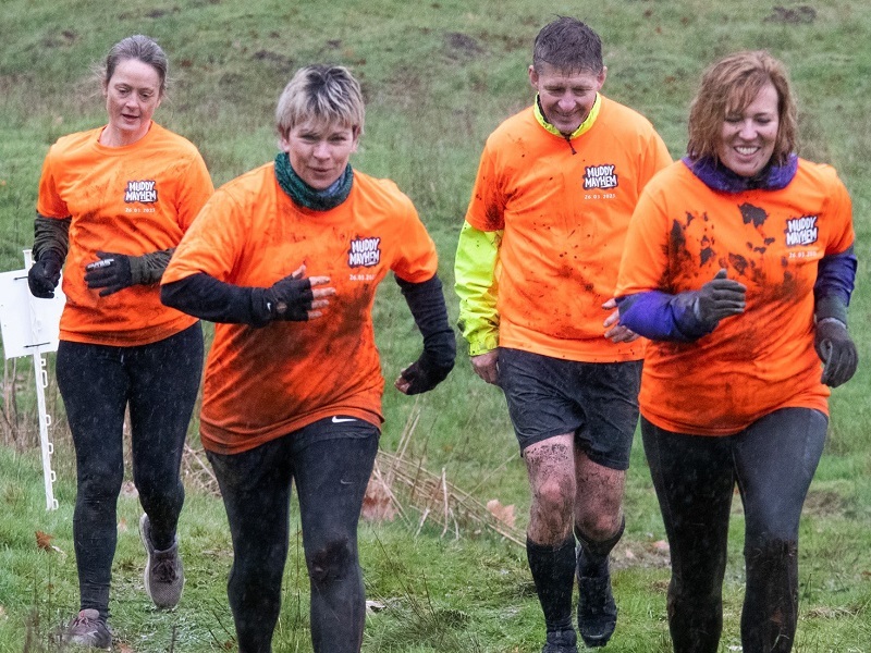 a-group-run-through-muddy-grass