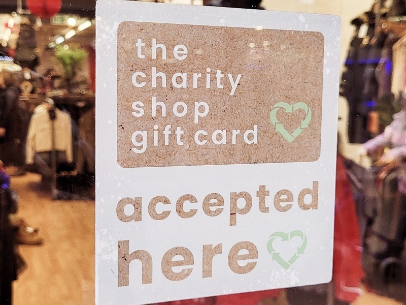 shop-window-containing-a-sign-that-reads-the-charity-shop-gift-card-accepted-here