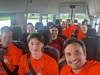 a-selfie-of-people-on-a-minibus-wearing-matching-orange-t-shirts