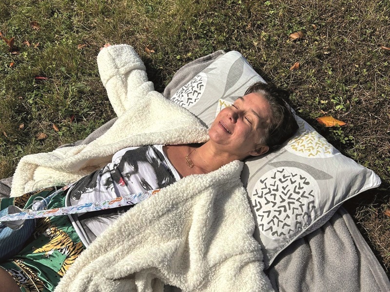 kelly-laying-on-pillows-on-the-grass-smiling