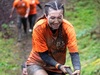 a-woman-pulls-herself-up-a-muddy-hill-using-a-rope