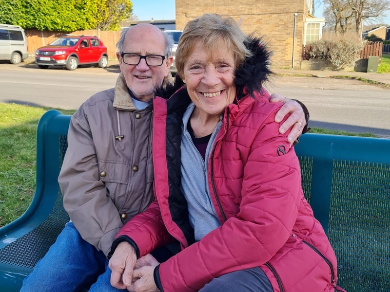 jules-parents-sitting-on-a-bench-smiling
