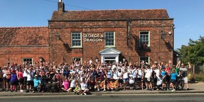 a-cheering-crowd-outside-a-pub-with-bikes