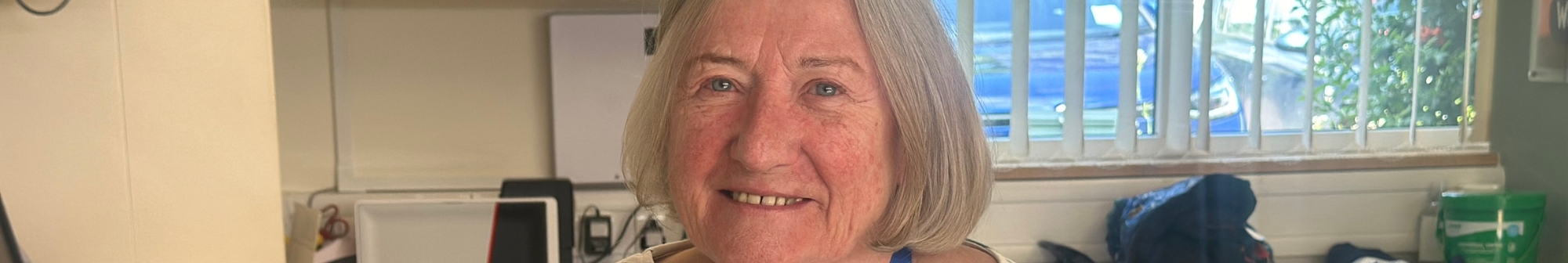 volunteer-receptionist-smiling-behind-reception-counter