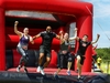 group-hold-hands-while-jumping-off-an-obstacle-at-the-inflatable-5k