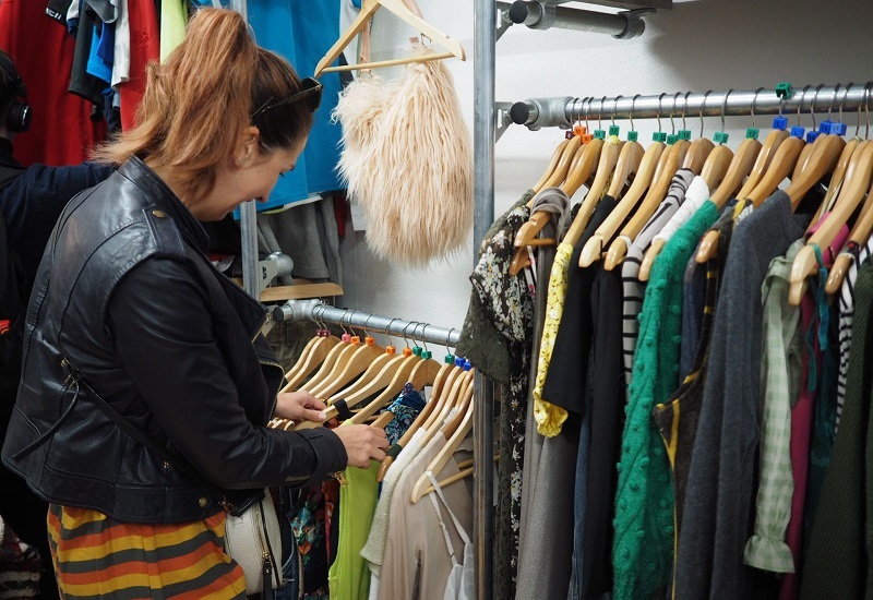 a-customer-browsing-through-clothes-on-a-rail