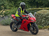 person-wearing-a-high-vis-jacket-riding-a-red-motorbike