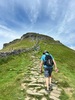 group-hiking-uphill-toward-mountain-summit-on-yorkshire-three-peaks-challenge
