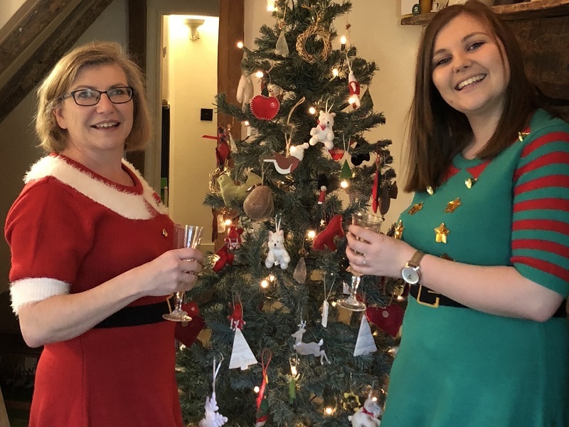 karyn-and-mary-wearing-festive-dresses-in-front-of-christmas-tree