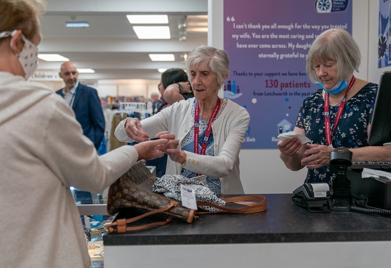 volunteer-shop-assistant-hands-a-customer-his-change