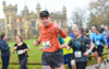 a-man-gives-a-thumbs-up-as-he-runs-with-others-past-Knebworth-House