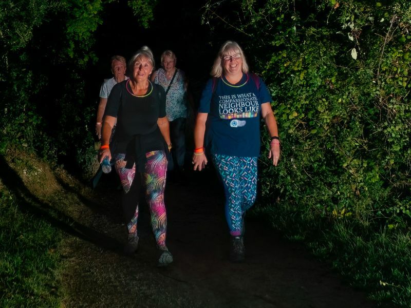 two-sunset-starlight-walkers-wearing-bright-leggings-and-glowsticks