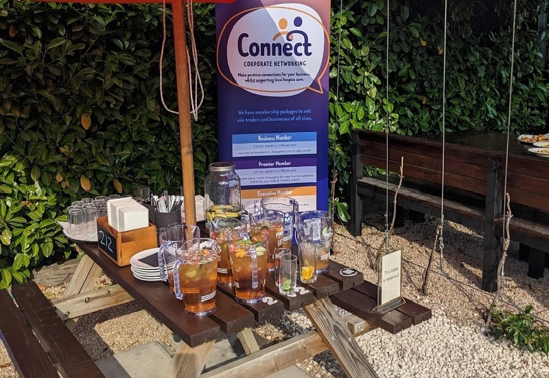 a-picnic-table-containing-drinks-in-front-of-connect-banner