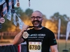 runner-holds-up-finishers-medal-at-the-flawed-hero-marathon