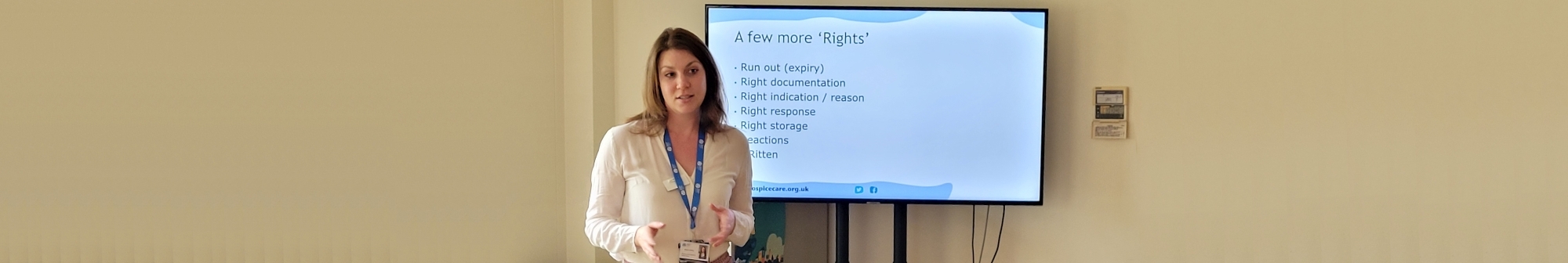 nurse-standing-in-front-of-a-tv-screen-delivering-training