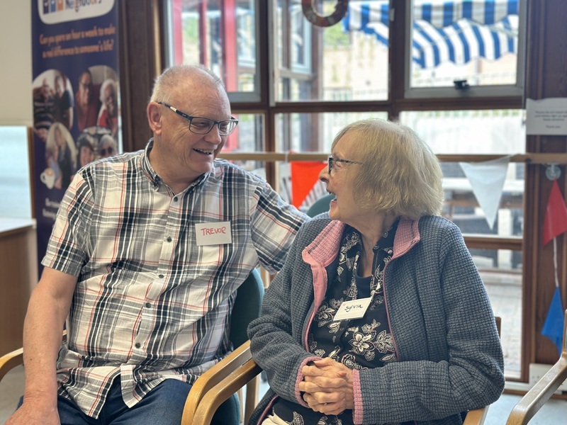 two-people-smiling-and-talking-at-the-healthy-memory-cafe-wellbeing-hub