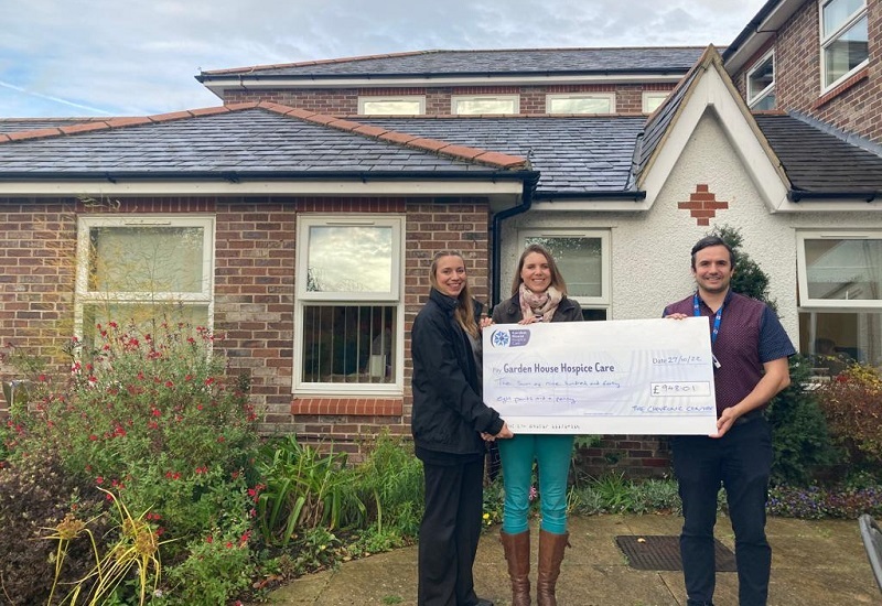 two-fundraisers-and-staff-member-hold-giant-cheque-outside-hospice