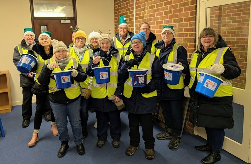 event-volunteers-wearing-christmas-hats-holding-collection-buckets