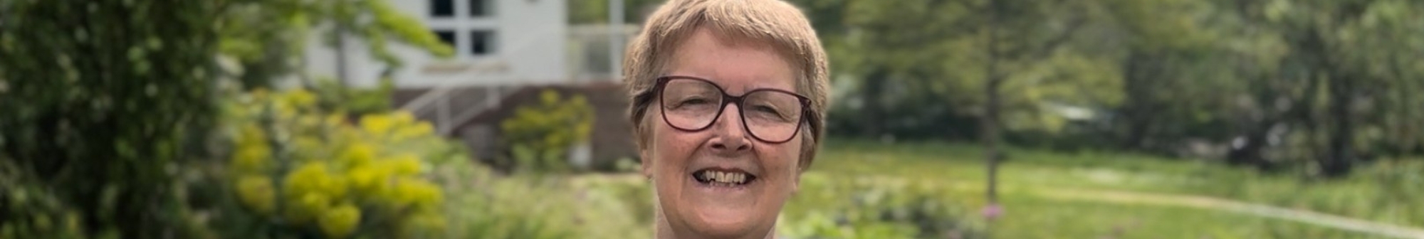 volunteer-angie-smiling-sat-in-the-hospice-gardens