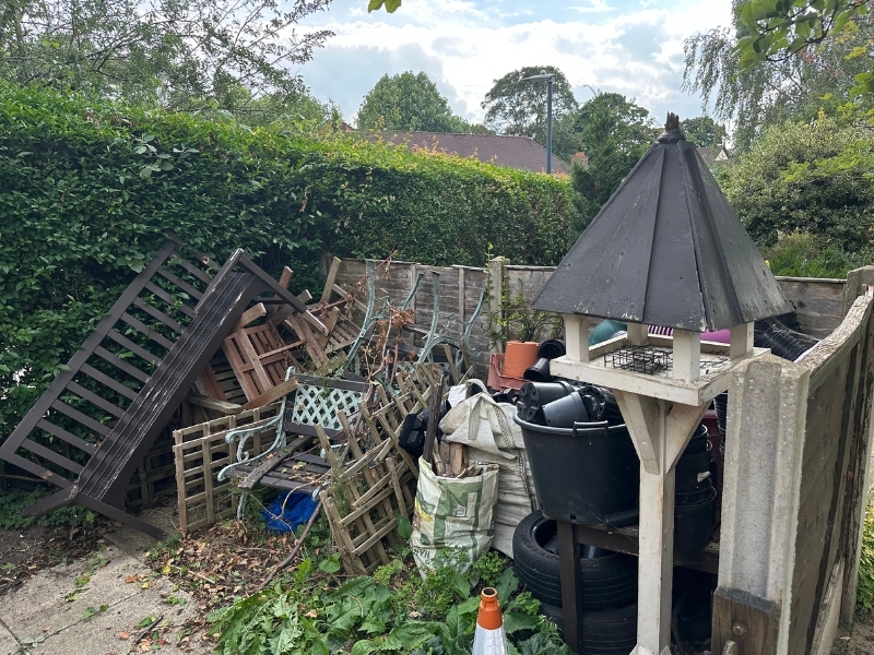 old-garden-furniture-piled-up-next-to-a-fence