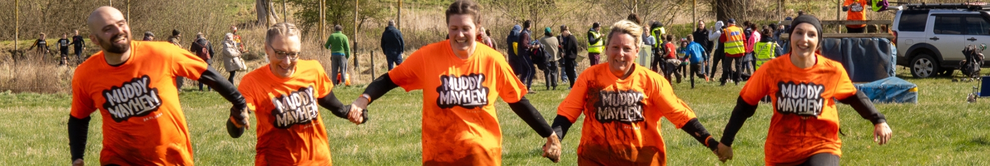 group-hold-hands-while-running-at-muddy-mayhem