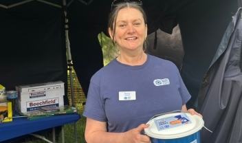 fundraising-volunteer-smiling-and-holding-up-a-collection-bucket