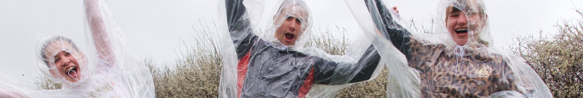 three-people-cheering-wearing-rain-covers