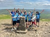 group-of-people-cheering-at-the-summit-of-a-mountain