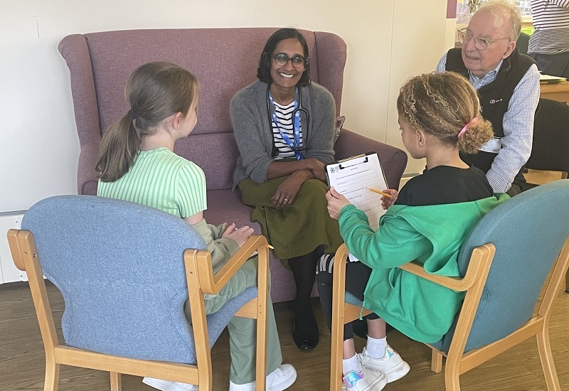 two-girls-talk-to-doctor-and-community-member