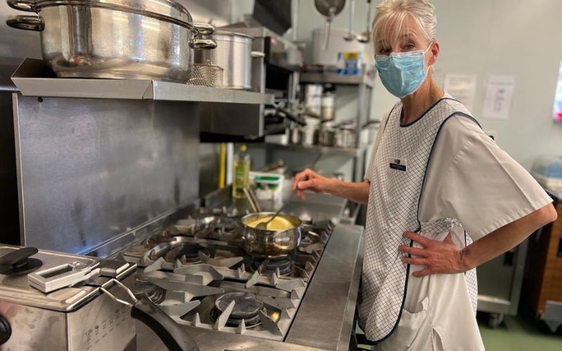 woman-wearing-apron-stirs-pot-on-overn