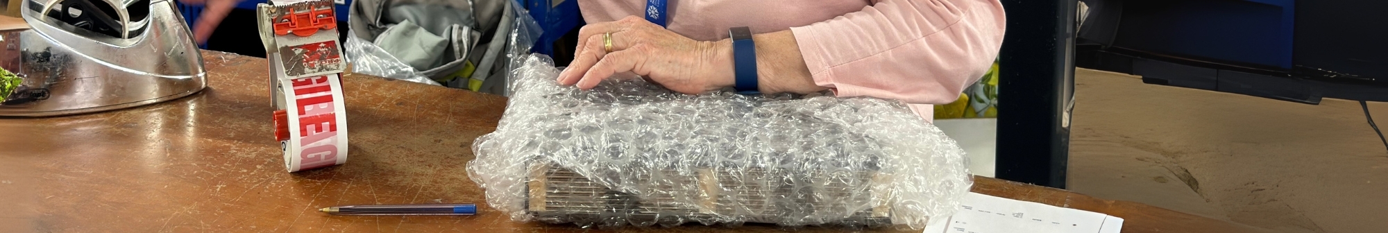 volunteer-packing-an-item-in-bubble-wrap