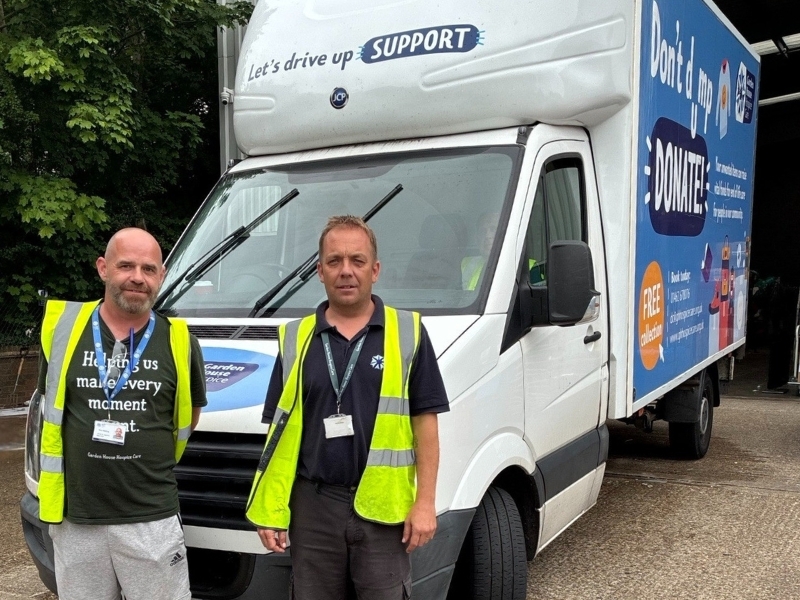 two-trading-staff-stand-and-smile-in-front-of-a-hospice-branded-van
