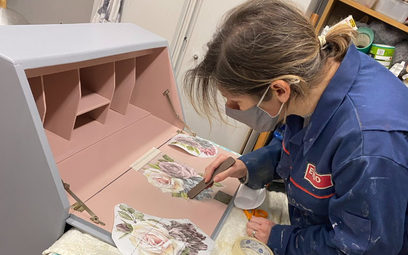 a-woman-in-a-mask-decorates-a-desk