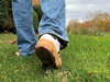 close-up-of-persons-shoes-and-jeans-walking-in-grass