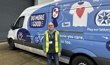 volunteer-stands-and-smiles-in-front-of-hospice-branded-van