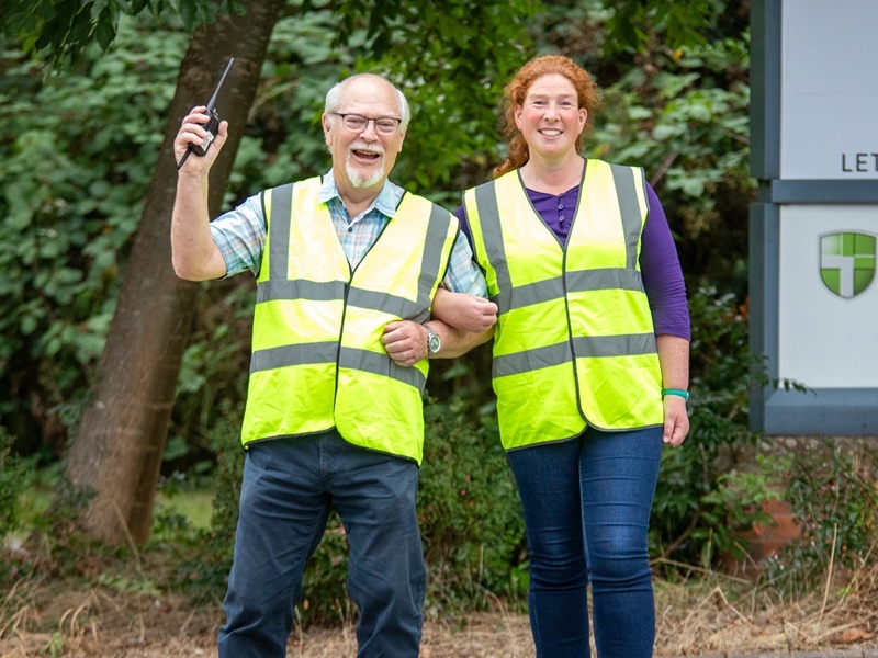 two-events-volunteers-linked-arm-in-arm-smiling-at-the-camera