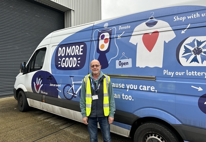 volunteer-stands-and-smiles-in-front-of-hospice-branded-van